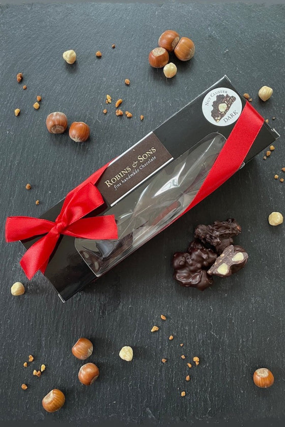 Box of whole and chopped hazelnuts covered in dark chocolate
